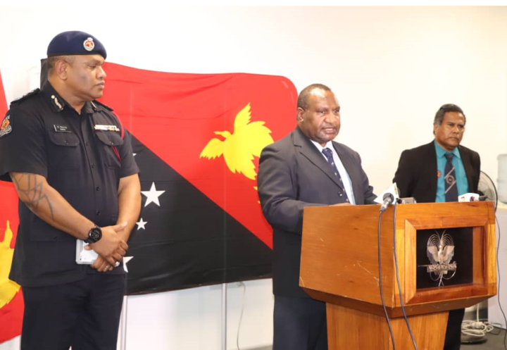PNG prime minister James Marape (centre) announces provisions for the 14-day state of emergency beginning Tuesday 24 March, alongside police commissioner David Manning and health secretary Paison Dakulala.