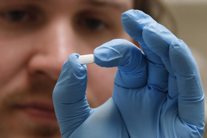 A pharmacy tech holds a pill of Hydroxychloroquine in Utah, on 20 May. 