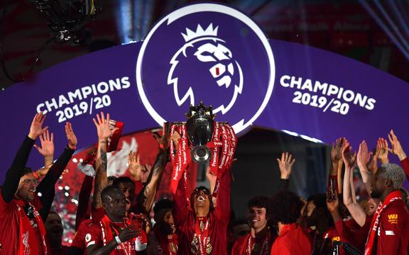 Liverpool's Brazilian midfielder Roberto Firmino (C) lifts the Premier League trophy during the presentation following the English Premier League football match between Liverpool and Chelsea at Anfield in Liverpool, north west England on July 22, 2020. 