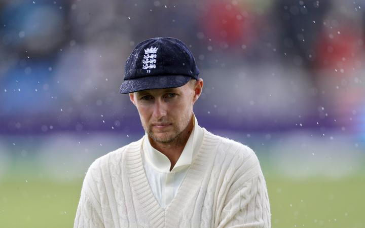 England captain Joe Root walks off in the rain.