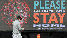 A man walks past a sign on a truck in Melbourne, as the city enforces strict lockdown restrictions.