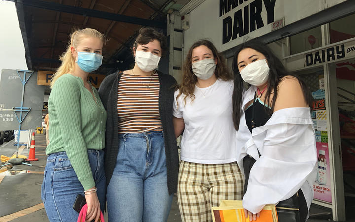 University students in Auckland, Rebekah Levesque, Josephine Palmer, Dannii Cooke and Vanessa Be, wear masks as they pick up supplies.
 