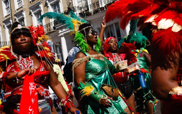 Paraders in feathered costumes make their way along Chepstow Road on the second and final day of the 2019 Notting Hill Carnival in London, England, on August 26, 2019. 