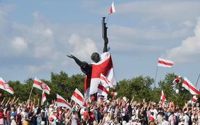 Belarus opposition supporters hold former white-red-white flags of Belarus used in opposition to the government, during a demonstration in central Minsk on August 16, 2020.