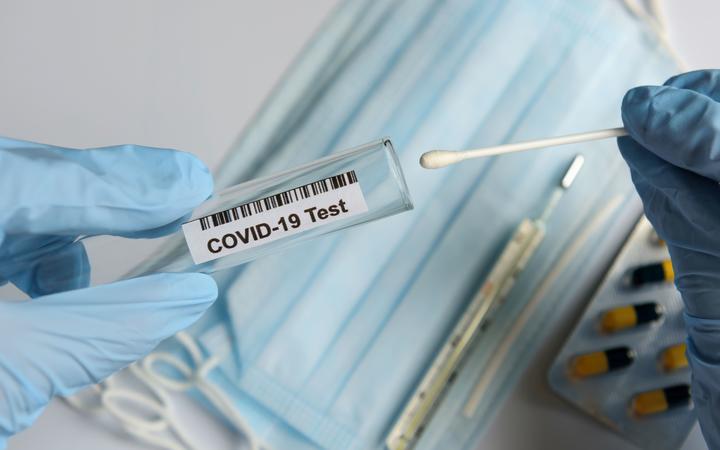 Hands in medical gloves holding COVID-19 swab. Test tube for taking patient sample, PCR DNA testing protocol process. Nasal swab laboratory test in hospital lab.