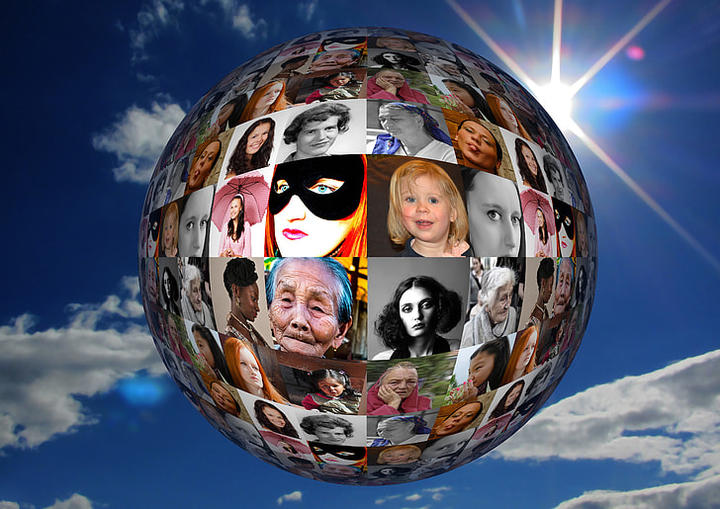 A globe covered with pictures of women againts a blue sky.