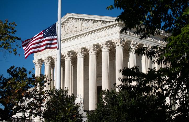 The American flag flies at half staff for late US Supreme Court Justice Ruth Bader Ginsberg outside the US Supreme Court in Washington, DC