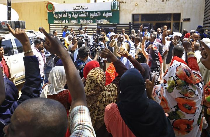 People chant slogans outside the Judicial and Legal Science Institute that serves as a make-shift courthouse for the trial of Sudan's ousted president Omar al-Bashir along with 27 co-accused over the 1989 military coup that brought Bashir to power.