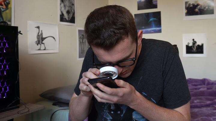 Josh Davies uses his magnifying glass to check a message.