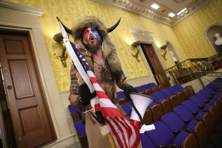 Jacob Anthony Chansley is alleged to be the man seen wearing horns and a fur hat in photographs, including this from inside the Senate chamber.