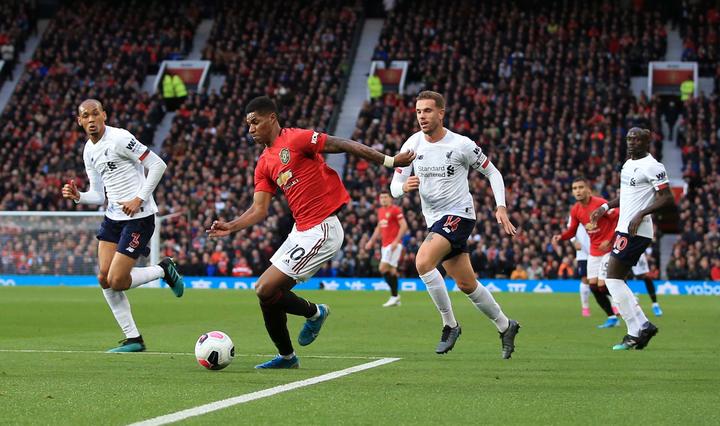 Marcus Rashford of Manchester United is surrounded by Liverpool defenders.
