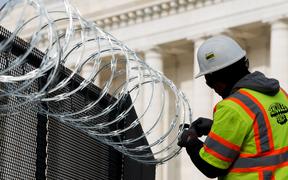 WASHINGTON, DC - JANUARY 15: Work crews install razor wire on top of the fencing surrounding the US Capitol ahead of the inauguration on January 15, 2021 in Washington, DC. 