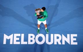 Serbia's Novak Djokovic kisses the Norman Brooks Challenge Cup trophy after winning against Austria's Dominic Thiem in their men's singles final match on day fourteen of the Australian Open tennis tournament in Melbourne on February 3, 2020. 