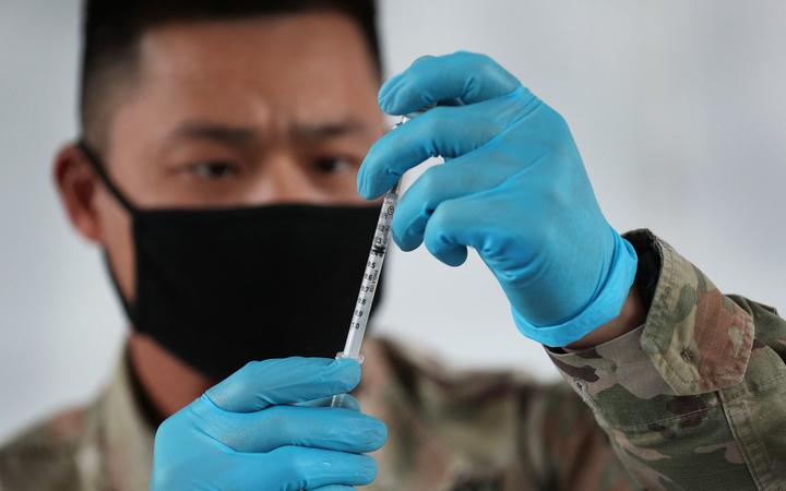 NORTH MIAMI, FLORIDA - MARCH 09: A U.S. Army soldier from the 2nd Armored Brigade Combat Team, 1st Infantry Division, prepares Pfizer COVID-19 vaccines to inoculate people at the Miami Dade College North Campus on March 09, 2021 in North Miami, Florida. 