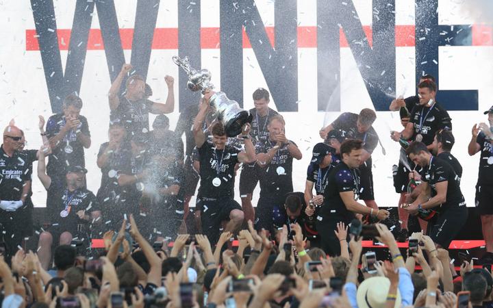 Team New Zealand's skipper Peter Burling (C) holds the America's Cup, affectionately known as the Auld Mug, after winning the 36th America's Cup against Luna Rossa Prada in Auckland on March 17, 2021.