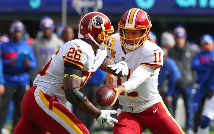 Washington Redskins quarterback Alex Smith hands the ball off to running back Adrian Peterson, 2018.