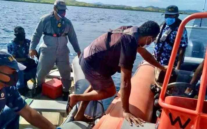 A Fijian Navy crew hand over the survivors found on board the FV TIRO II to Fiji police.