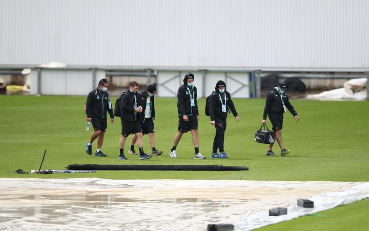 New Zealand players and staff make their way across the wet Ageas Bowl, Southampton.