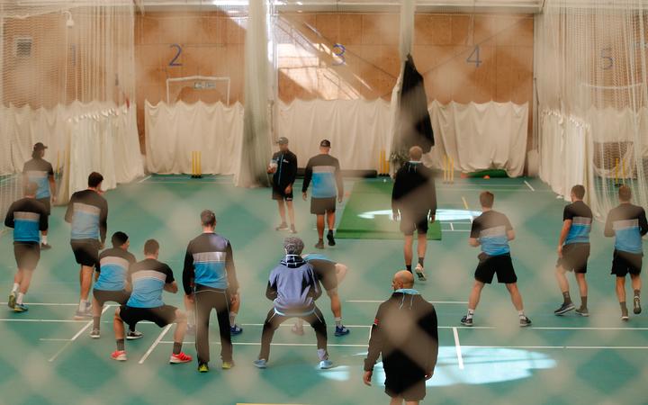 Black Caps players stretching and warming up in the indoor nets
