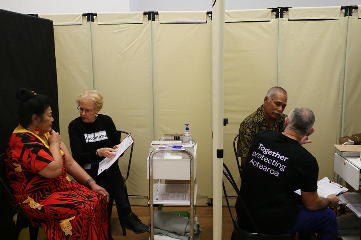 Malia Su-emalo Lui (left cubicle) and Seumanu Va'a Robertson (right) receive information about Covid-19 vaccination before receiving the jab at a public vaccination event arranged by the Catholic Church in Wellington, 9 June 2021.