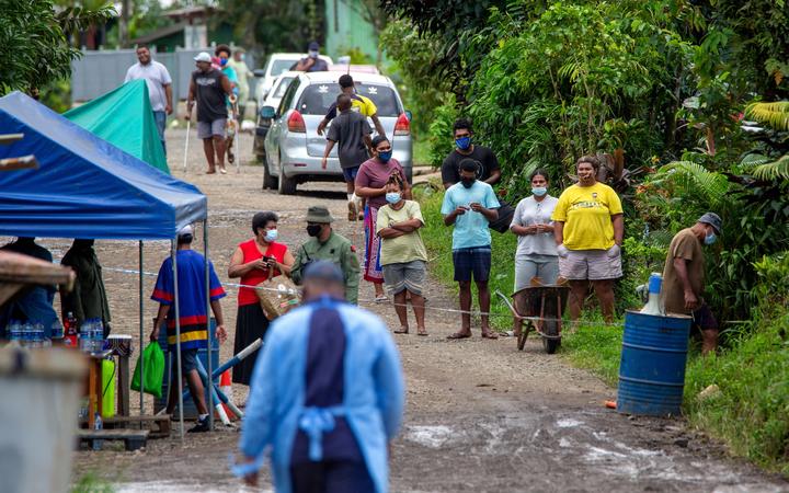 Residents look on as police check people are wearing face masks in Suva,  as a worsening outbreak of the Covid-19 coronavirus Delta variant has overwhelmed the South Pacific nation's largest hospital. 