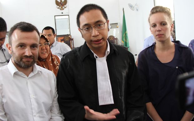 Two detained French journalists Thomas Dandois (L) and Valentine Bourrat (R) listen to their lawyer after their trial in Jayapura.