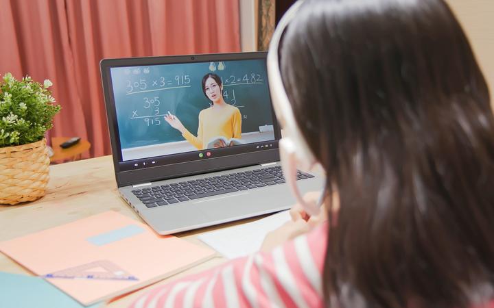 asian girl is learning math and looking elementary school female teacher teaching online through laptop at home, remote learning