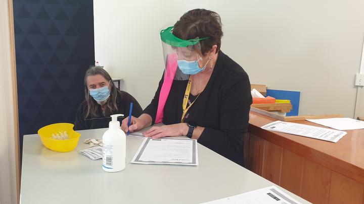 Tui Ora clinical nurse Robyn Taylor completes paperwork before doing another vaccination.