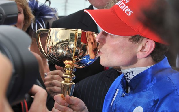 English jockey Ryan Moore kisses the trophy after winning the Melbourne Cup with Germany's Protectionist.