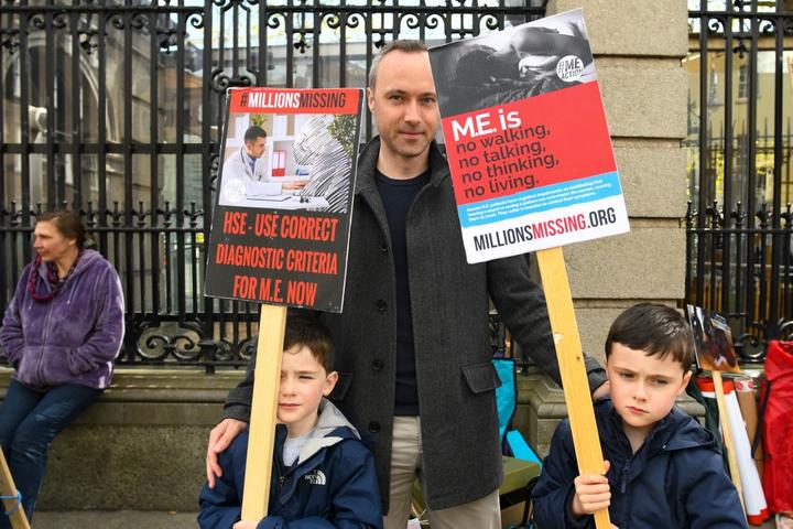 ME/CFS global movement #MillionsMissing campaigners outside the Irish Parliament demand increased government funding for research, clinical trials and medical education.
