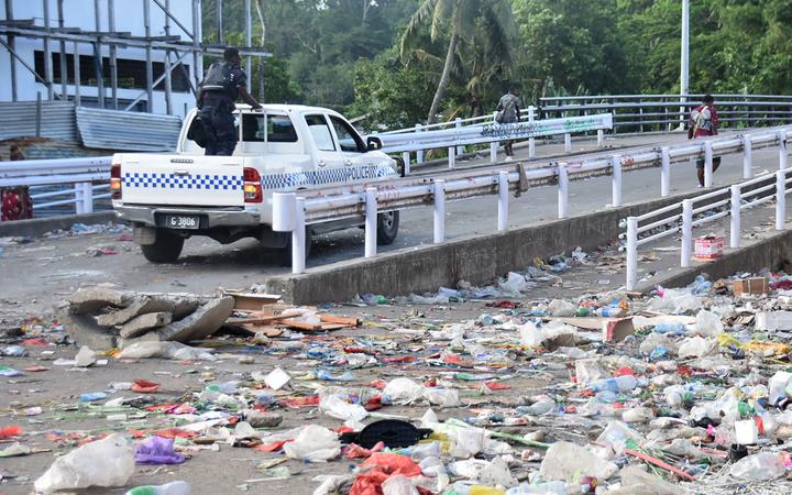 Un véhicule de police traverse le quartier chinois de Honiara aux Îles Salomon le 26 novembre 2021, après un troisième jour de violence qui a vu le domicile du Premier ministre être attaqué et des pans de la ville réduits en ruines fumantes