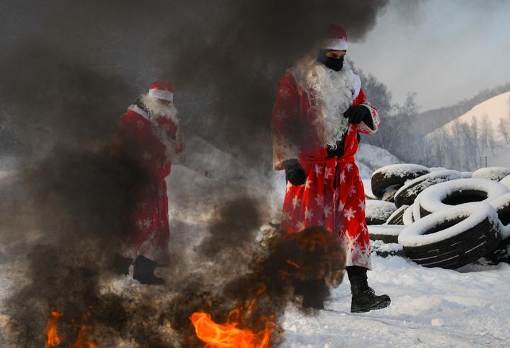 Russian National Guard officers dressed as Father Frost pass through the winter "Assault strip" in Kemerovo, Russia. 