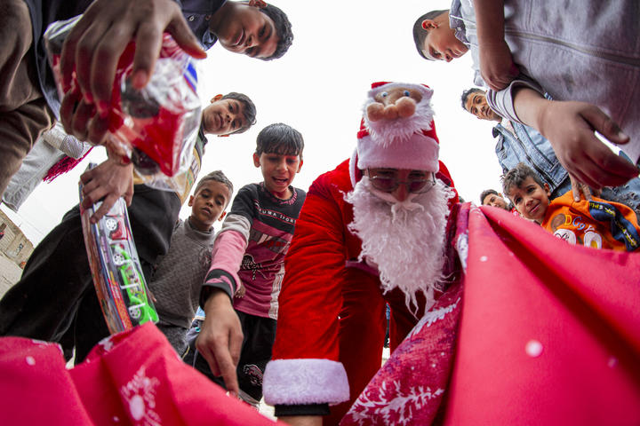 Mohamed Maarouf, de 28 años, vestido con el día de San Nicolás, distribuye regalos de Navidad en los barrios marginales de Basora, Irak.