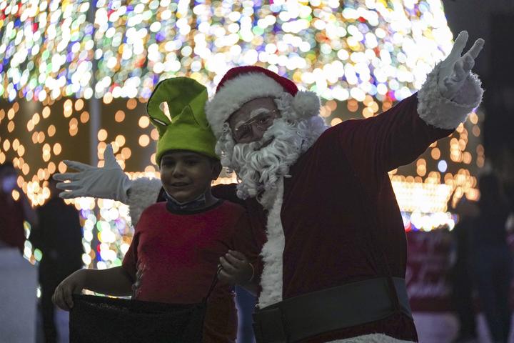 Un homme déguisé en Père Noël divertit les enfants sur la place Salvador del Mundo au Salvador.