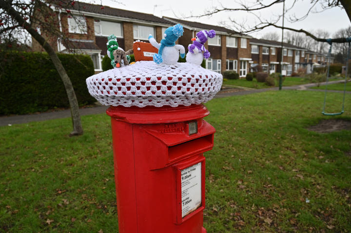 Une décoration de Noël de bonhommes de neige tricotés au sommet d'une boîte aux lettres rouge traditionnelle de Royal Mail à Shoreham, dans le sud de l'Angleterre, le 22 décembre. 