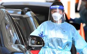 A member of the medical personnel takes details at a drive-through Covid-19 testing station in Melbourne on August 19, 2021, as Australia battles an outbreak of the Delta variant of coronavirus.