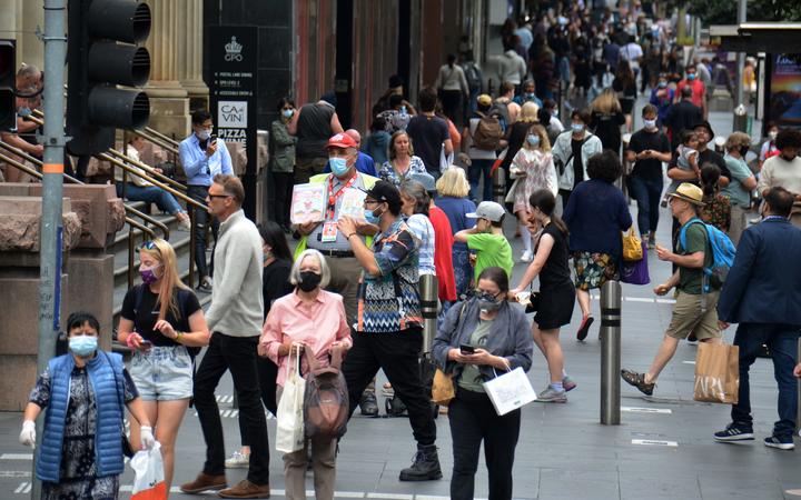 People wear face masks in central Melbourne as the number of Covid-19 community cases continues to spiral.