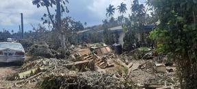 Ash and debris covering houses and a road in Nuku'alofa, Tonga.