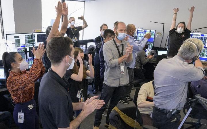 In this photo released by NASA, the James Webb Space Telescope mission operations team celebrates on January 8, 2022, at the Space Telescope Science Institute in Baltimore, Maryland, after confirming that the observatorys final primary mirror wing successfully extended and locked into place. 