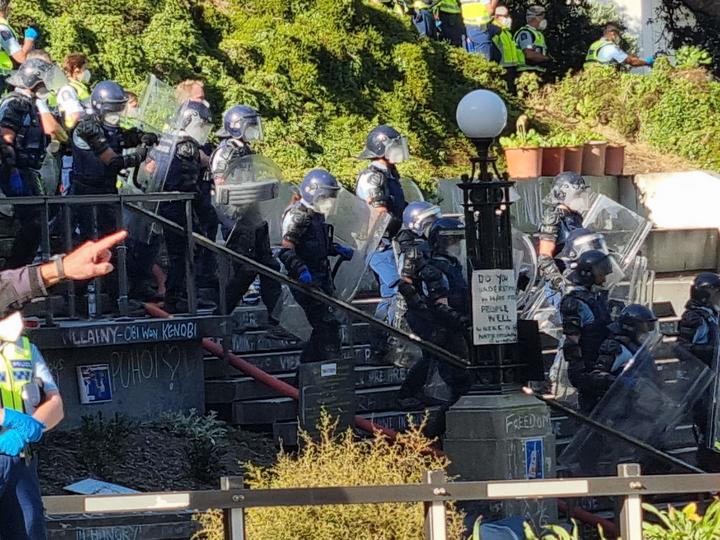 Police in riot gear at the steps at Parliament.