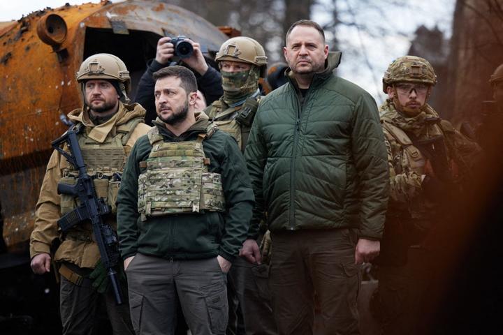 A handout picture taken and released on April 4, 2022 by Ukrainian presidential press service shows Ukainian President Volodymyr Zelensky (C) visiting the town of Bucha, northwest of the Ukrainian capital Kyiv.