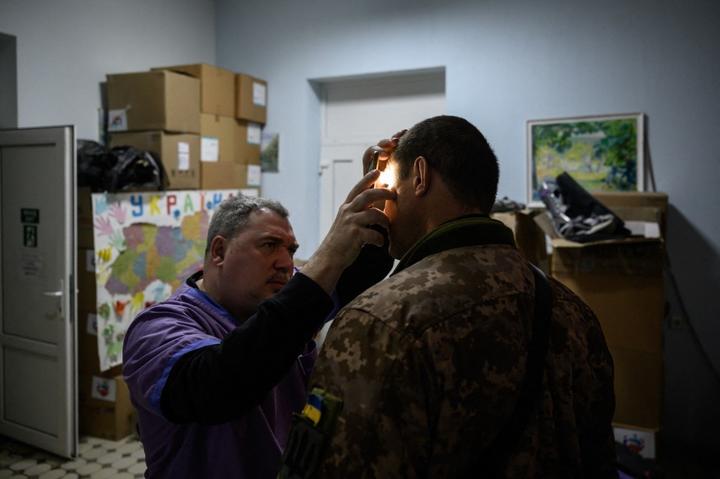 A medical staff member checks the eyes of a soldier at a military hospital in Zaporizhzhia on 18 April, 2022.