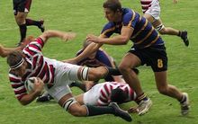 Rugby player being tackled during school game, Auckland.