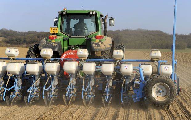 An agricultural machine sows crops.