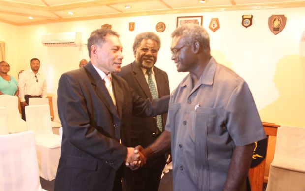 Solomon Islands Prime Minister Manasseh Sogavare congratulates Peter Shanel after taking his oath as Minister for Police. Looking on is the new finance minister Snyder Rini.