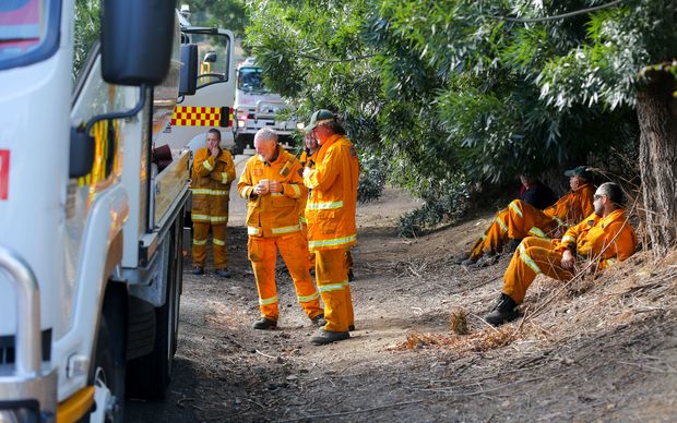 Volunteer fire fighters relax in the township of Gumeracha after fighting bush fires.