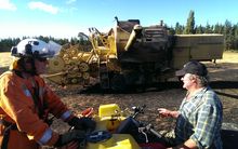 Volunteer firefighter Paul Fiddymont (left) talks to Michael Manion whose combine harvester sparked caused the fire.