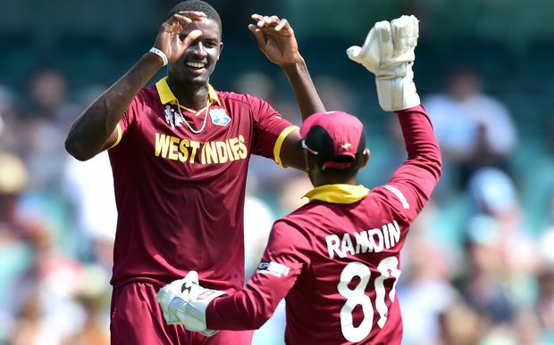 West Indies paceman Jason Holder (L) celebrates his wicket of South Africa's batsman Quinton de Kock (not pictured) with a teammate Denesh Ramdin during the Pool B 2015 Cricket World Cup match between South Africa and West Indies at the Sydney Cricket Ground on February 27, 2015.