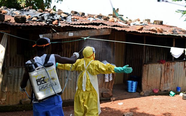 A health worker from Sierra Leone's Red Cross is sprayed with disinfectant in Freetown in November 2014 (file photo).