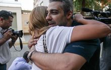 Canadian Al-Jazeera journalist Mohamed Fahmy hugs his wife Marwa after being dropped off by authorities following his release from jail.
